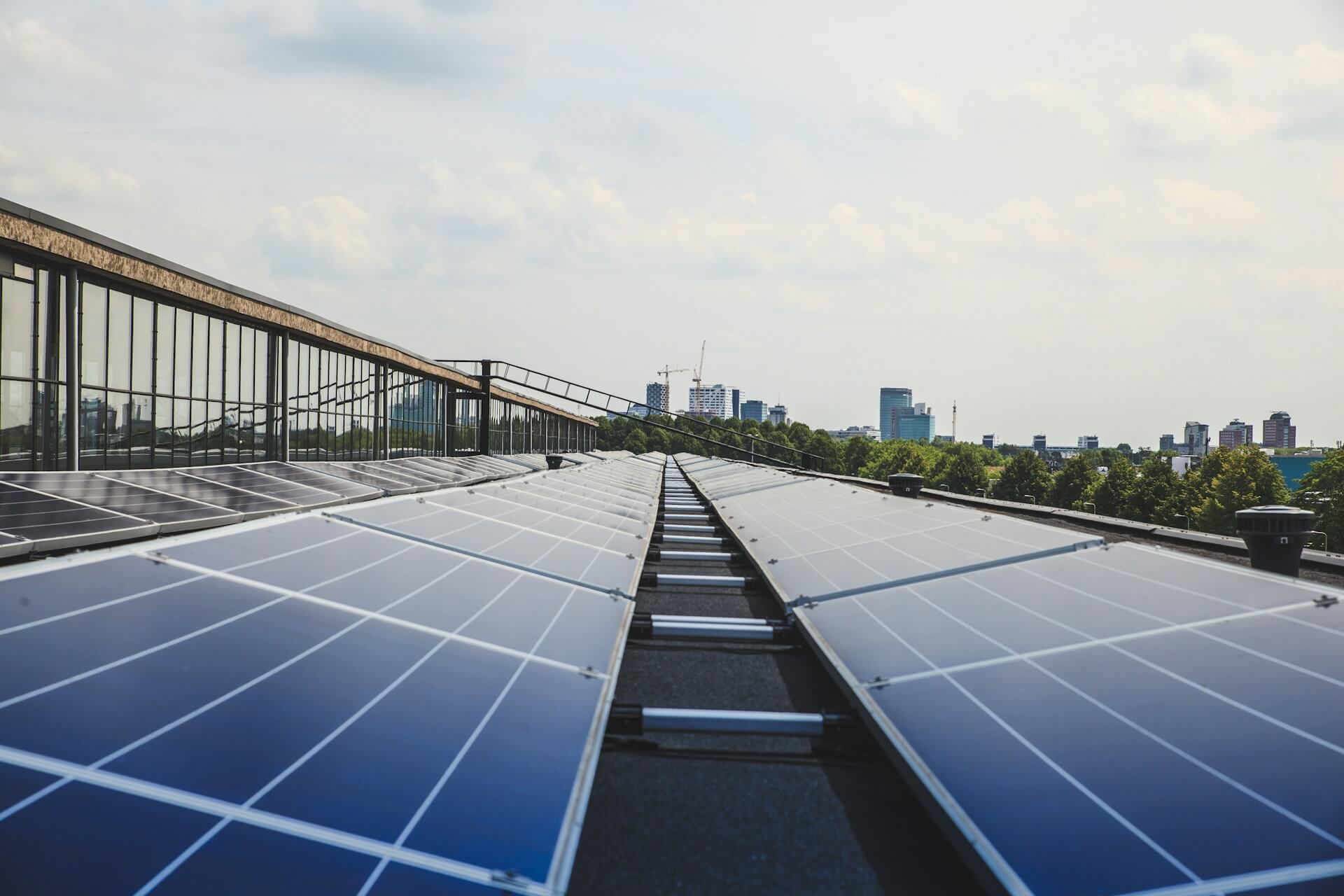 Vista de paneles solares en un edificio con vista a la ciudad al fondo